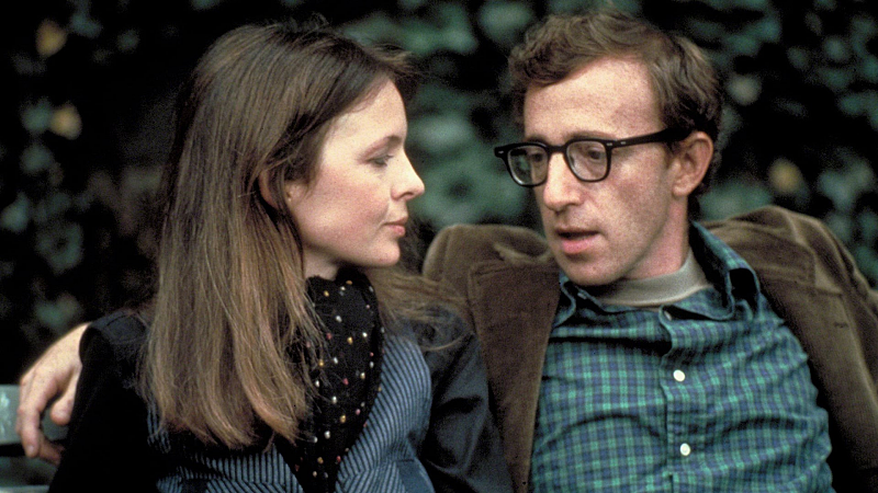 Diane Keaton and Woody Allen having a conversation on a park bench.