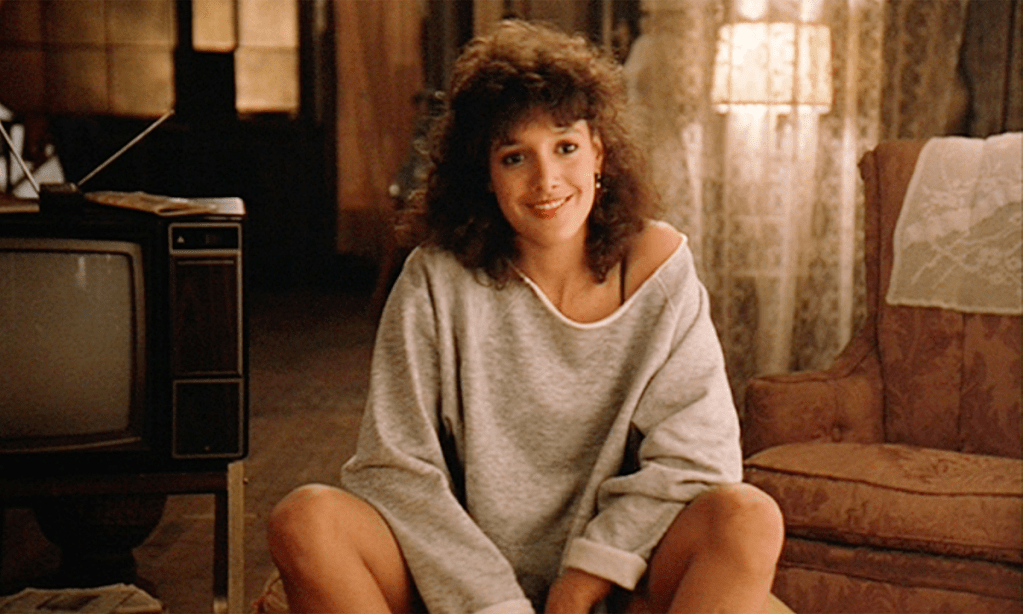 A dancer sits on the floor and smiles