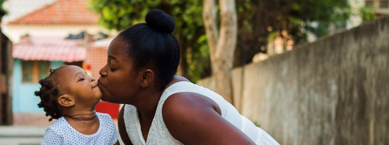 A mother gives her daughter a kiss