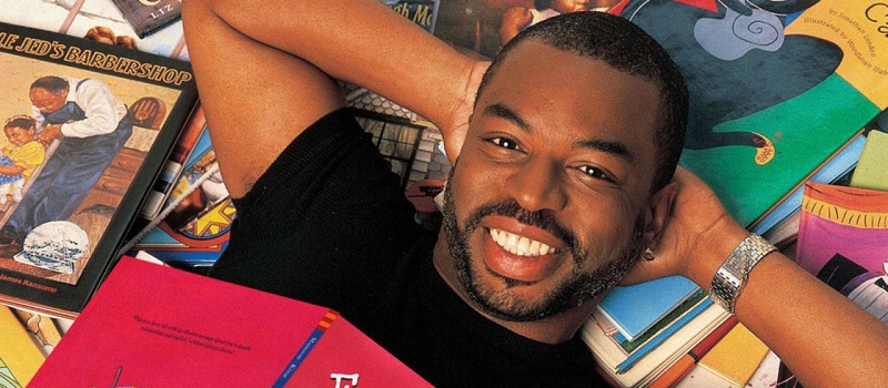 LeVar Burton lying on a stack of books.