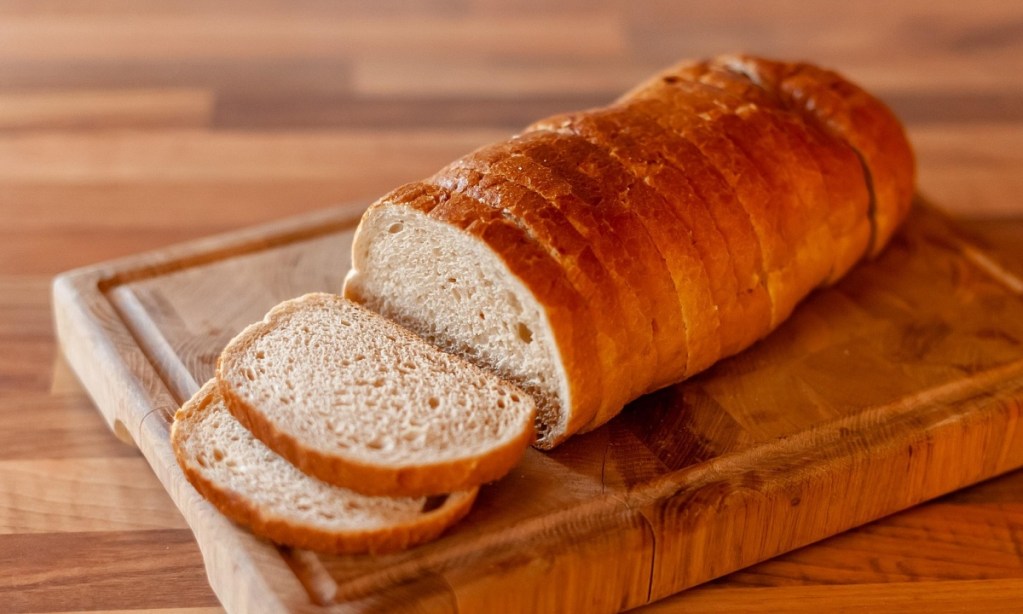A cutting board with sliced French bread