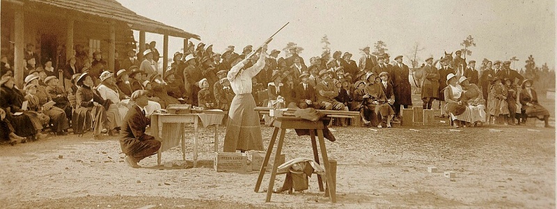Annie Oakley shooting in front of a crowd in Pinehurst, NC.