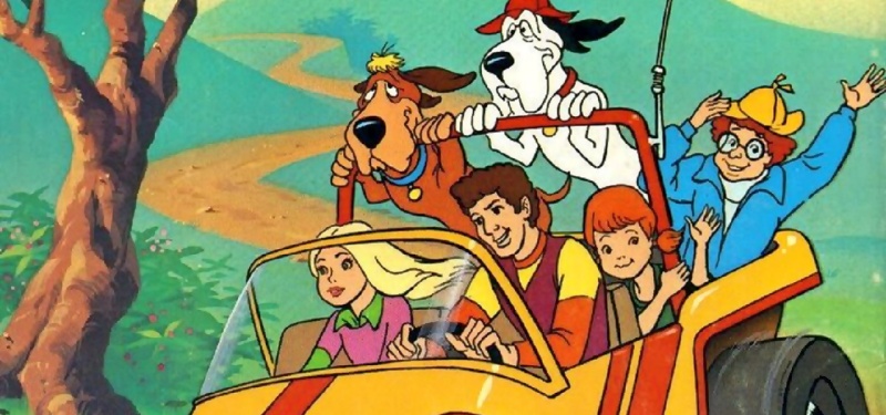 A group of teens and a couple of dogs ride in an open-air vehicle.