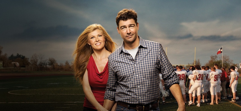 Connie Britton and Kyle Chandler holding hands on a football field