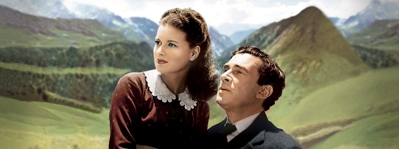 A woman is sitting on her husband's lap. Together they look at a shooting star