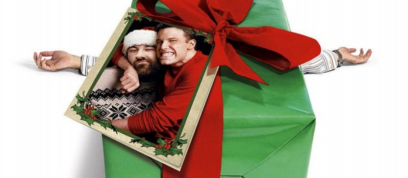 A Christmas present (with a photo of James Gandolfini and Ben Affleck attached to the bow) crushing the man underneath