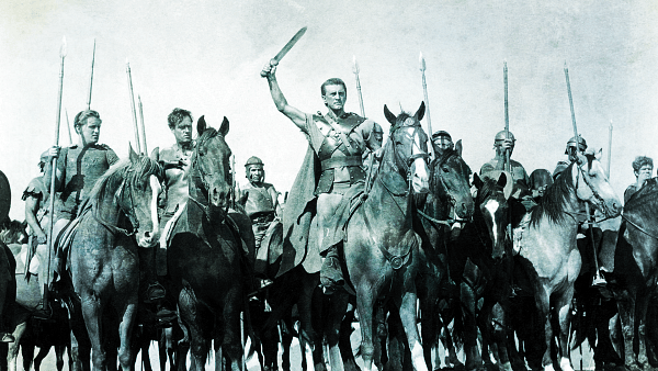 A historic scene from the film 'Spartacus' featuring Kirk Douglas leading a group of warriors on horseback, holding swords and preparing for battle.