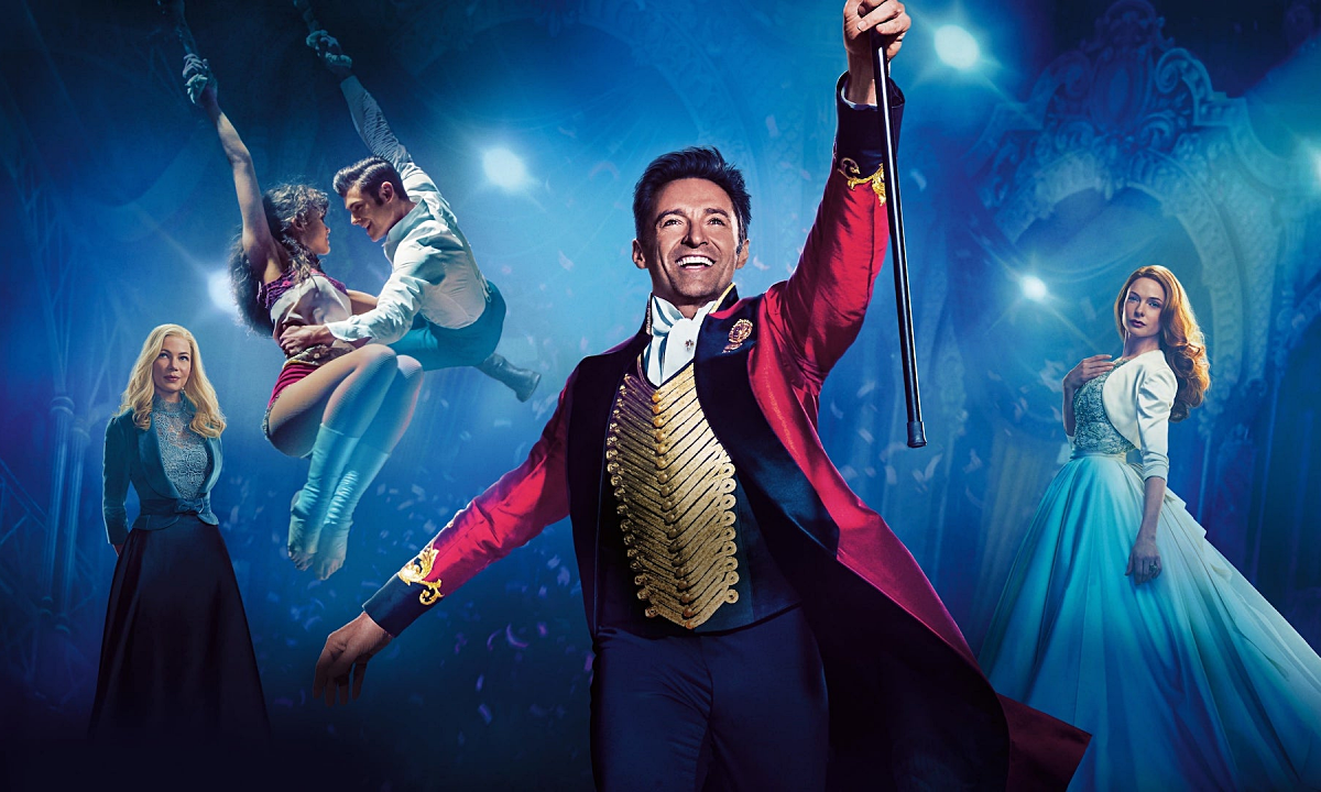 A ringmaster stands in front of other circus performers.