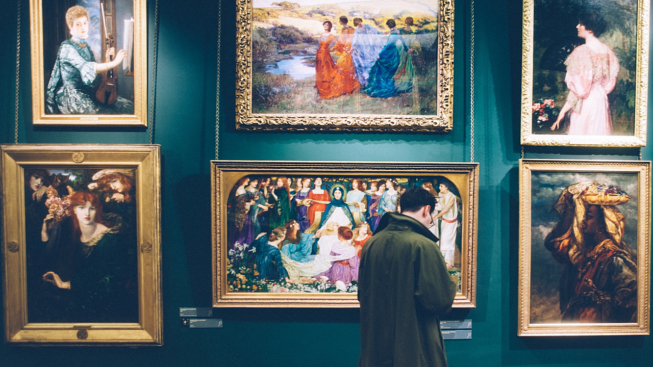 man looking at painting