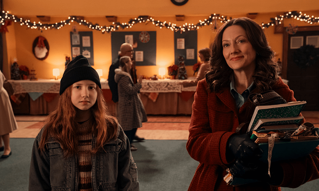 A young girl and an adult woman look forward smiling