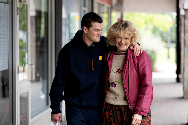 Robert Aramayo and Maxine Peake walking together in "I Swear"
