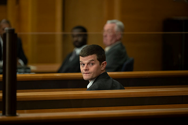 Robert Aramayo looks behind him in a courtroom setting in "I Swear"