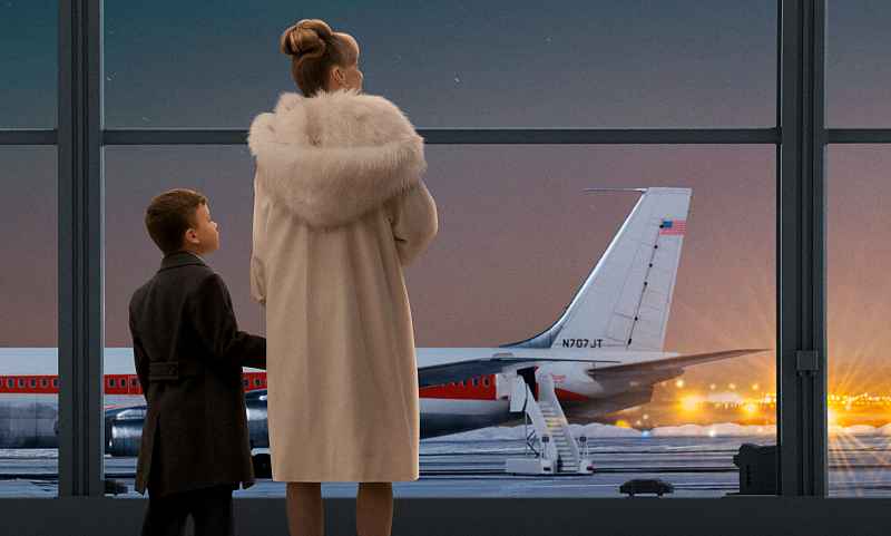 A boy and his mom look at an airplane from inside the airport. - from Propeller One-Night Coach