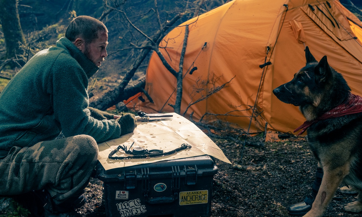 Brad Pitt and a German Shepherd at a camp site in the movie "Heart of the Beast"